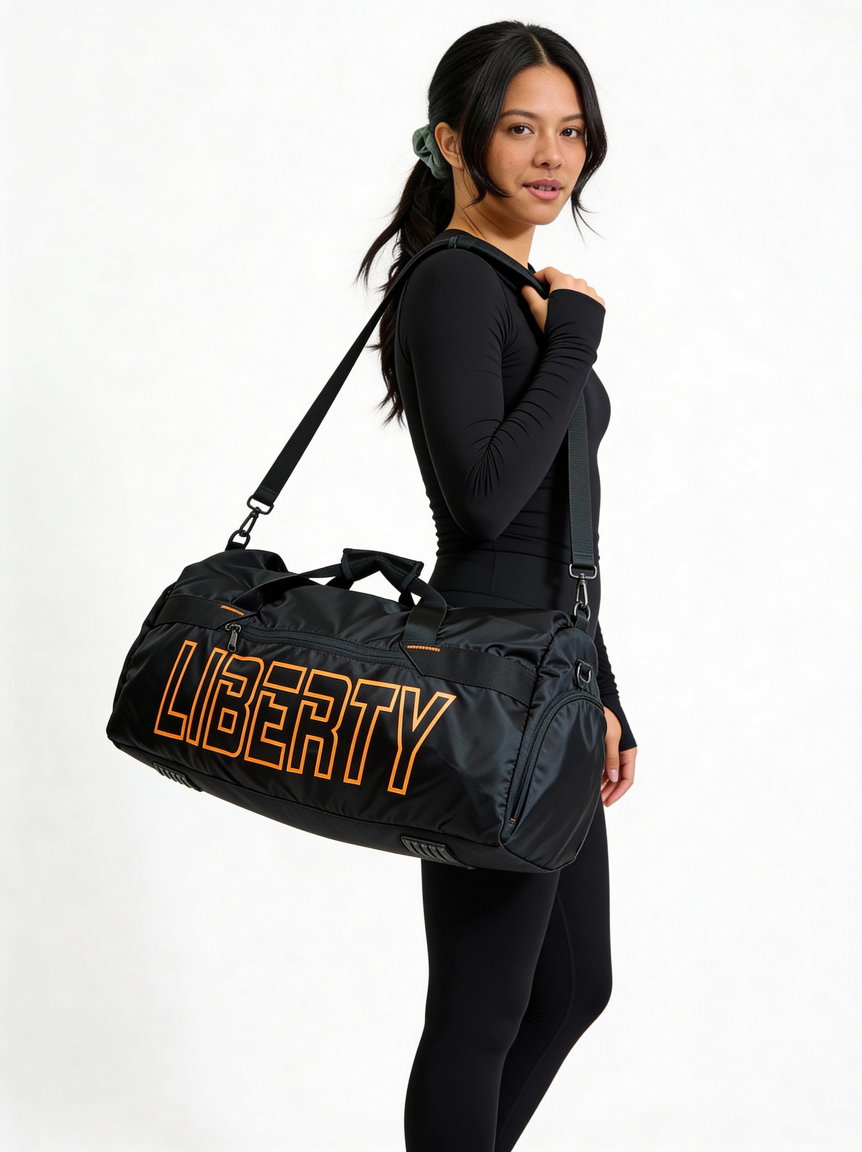 Woman carrying a black duffel bag with 'LIBERTY' branding on a white background
